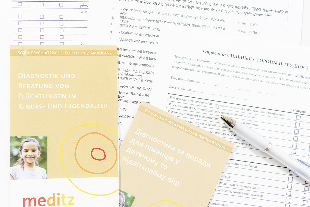 Informationsblätter und Fragebogen in verschiedenen Sprachen zur Flüchtlingssprechstunde bei Meditz.